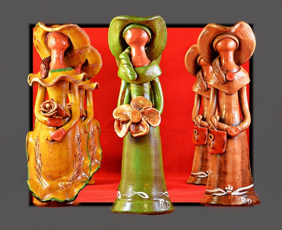 Three faceless dolls from the Dominican Republic dressed in yellow, green and brown dresses