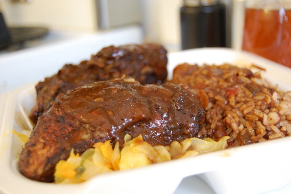 A plate of Jamaican jerk chicken with salad and rice