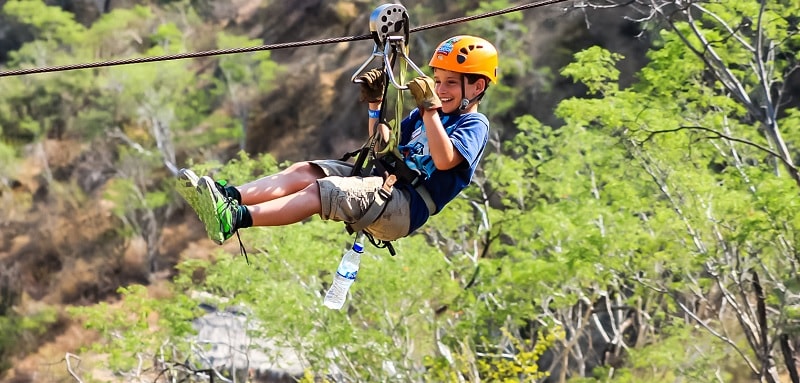 Boy riding a monster zipline in Cabo