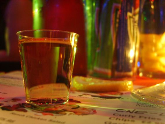 A shot of tequila under colorful lighting