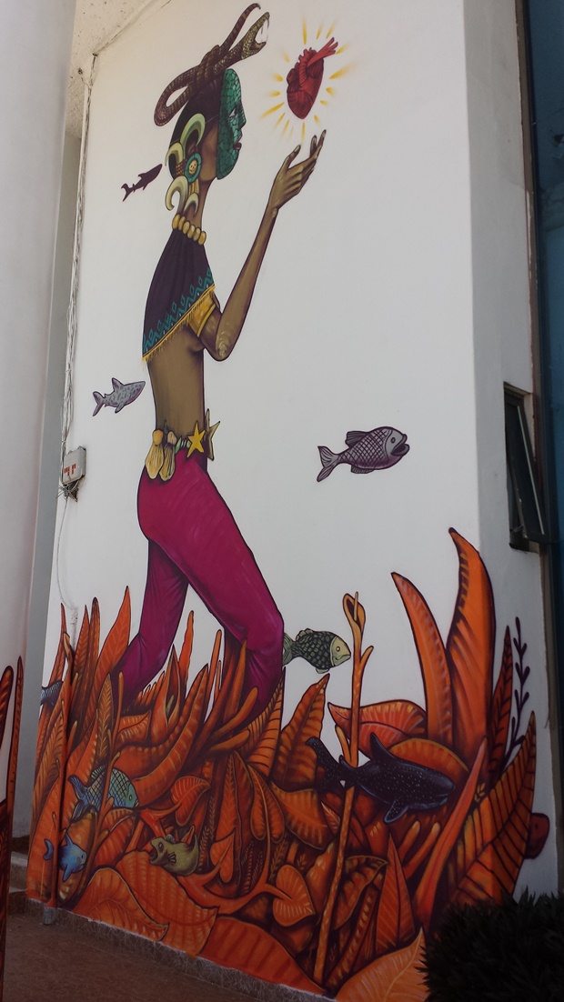 A mural painted by Mexico City based street artist Saner of the goddess Ixcel reaching her hand out to touch a heart on the island of Isla Mujeres, Mexico