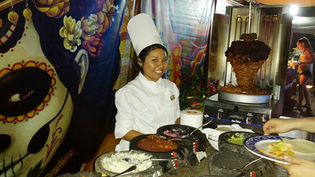 A chef at Secrets The Vine stands behind the buffet, waiting to serve guests delicious Mexican tacos and their condiments