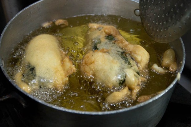 Poblano peppers being fried for a chile en nogada recipe