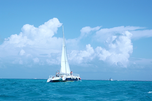 A white catamaran sails the azure waters of the Caribbean Sea off the coast of the Riviera Maya, Mexico