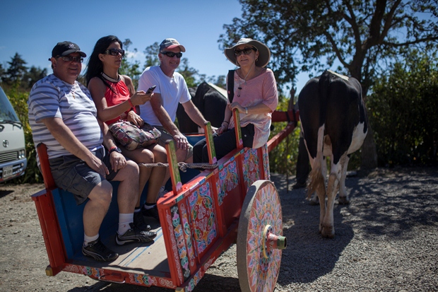 A colorful ox cart pulls a group of tourists in Costa Rica