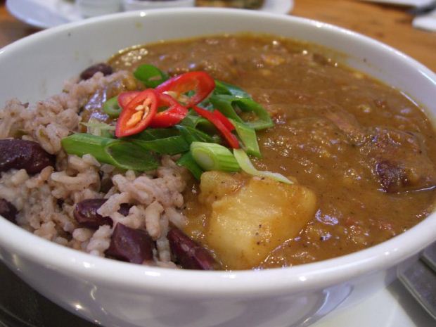 A plate of Jamaican curried goat serve with rice and beans in coconut milk