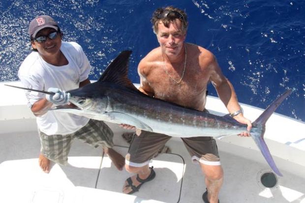 Fishermen off the coast of Puerto Morelos with their catch of the day: a swordfish