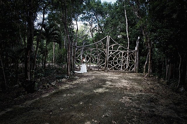 A bride standing at the gates of a a hacienda in the Riviera Maya, Mexico