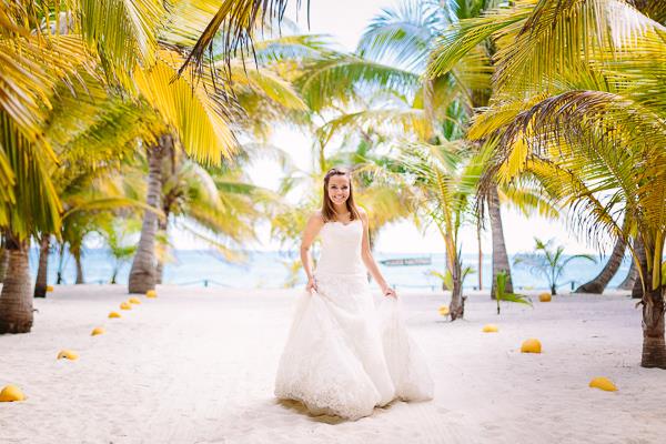 A bridal model walking down the white sand aisle in front of the Caribbean Sea at Mexico's Riviera Maya