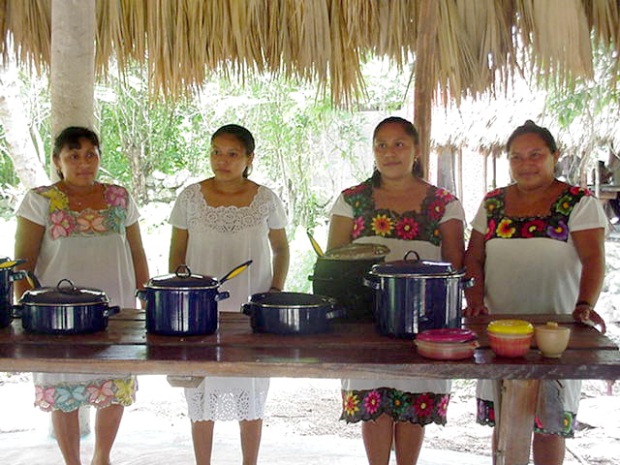 A group of Maya women stand in front of the food they prepared for the guests of the Ek Balam tour