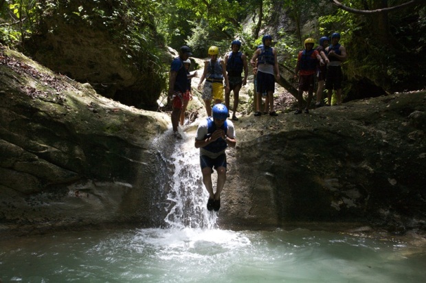 A man jumps from a small waterfall into the water below at the Damajagua Cascades in Puerto Plata