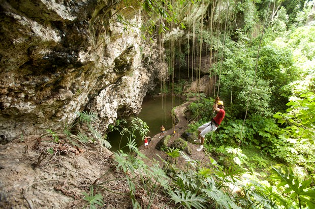 A young man rappels down into an underwater cave in the Riviera Maya, Mexico