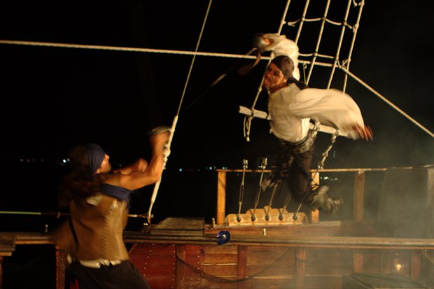 A pirate makes an aerial assault on another pirate on an Amstar dmc pirate tour aboard the Jolly Rogers boat