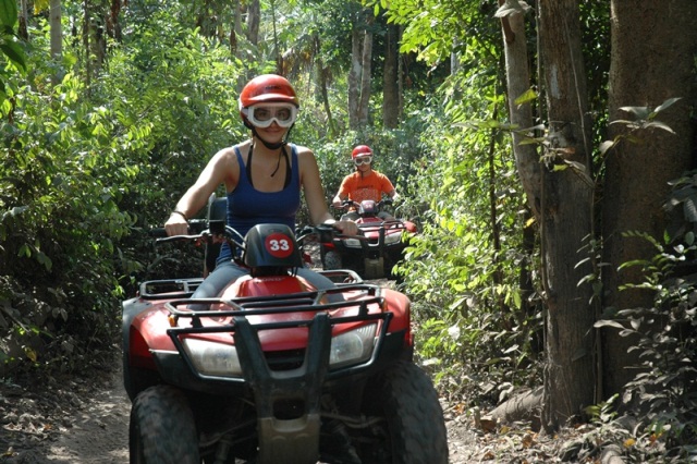 Tourists race through the jungle on the ATV tour on Cozumel Island, Mexico