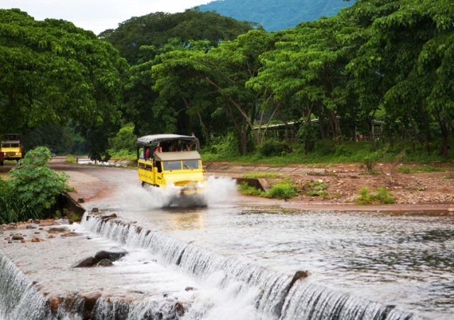 A Mercedes Benz unimog crosses a a river in the Sierra Madre Mountains right outside of Puerto Vallarta on the Amstar dmc Offroad Adventure tour.