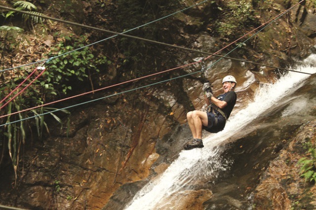 A man zip lines over a waterfall in the Sierra Madre Mountains just outside of Puerto Vallarta on the Outdoor Adventure tour organized by Amstar dmc.