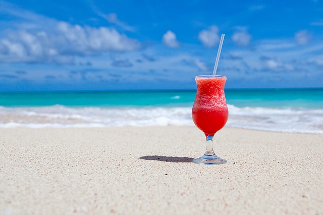 A frozen daquiri is placed on the sand in front of the Caribbean Sea at Bayahibe Beach in La Romana, Dominican Republic