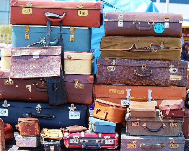 Many different pieces of luggage are stacked upon one another