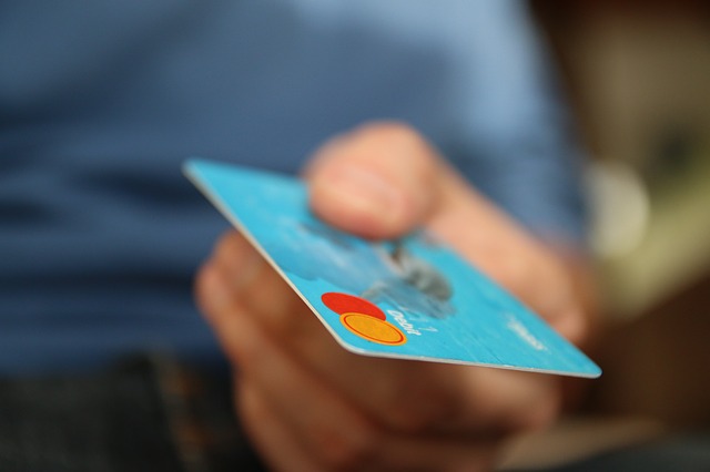 A man is holding a credit card in his hand