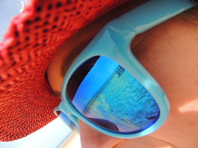 A woman looks out at the beach in La Romana and the Caribbean Sea is reflected in her sunglasses