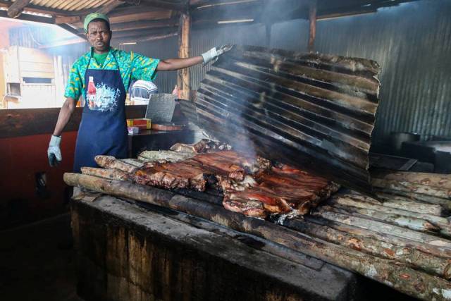 A cook stands over his jerk pit at Scotchies Restaurant in Montego Bay, Jamaica.