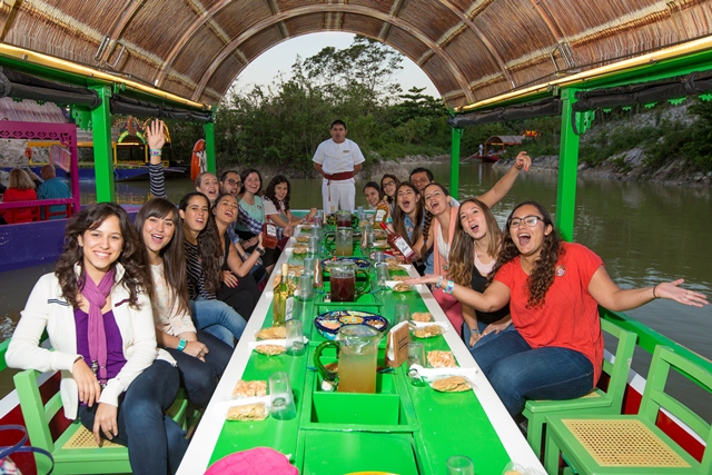 Guests aboard a wooden trajinera at Xoximilco Park