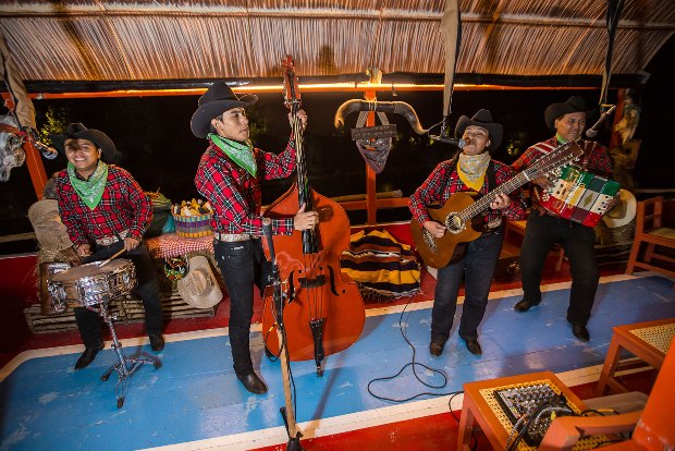 Musicians play aboard a wooden trajinera at Xoximilco Park