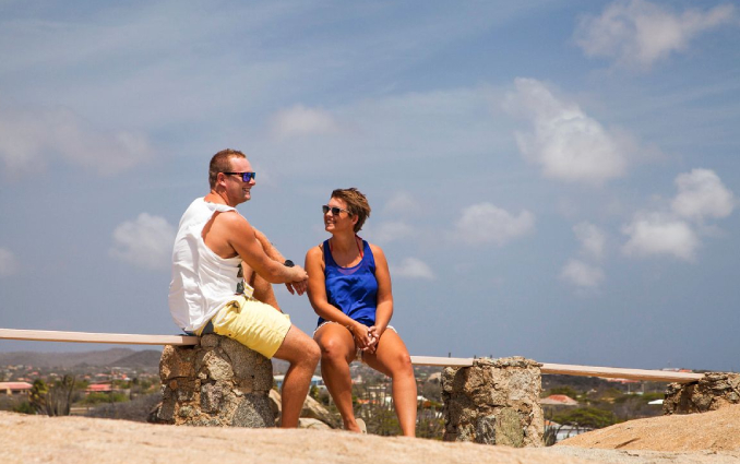 Couple sitting in a rock at the sightseing tour in Aruba