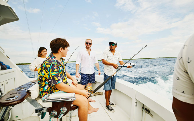 A guide explaining to a group of person how to fish