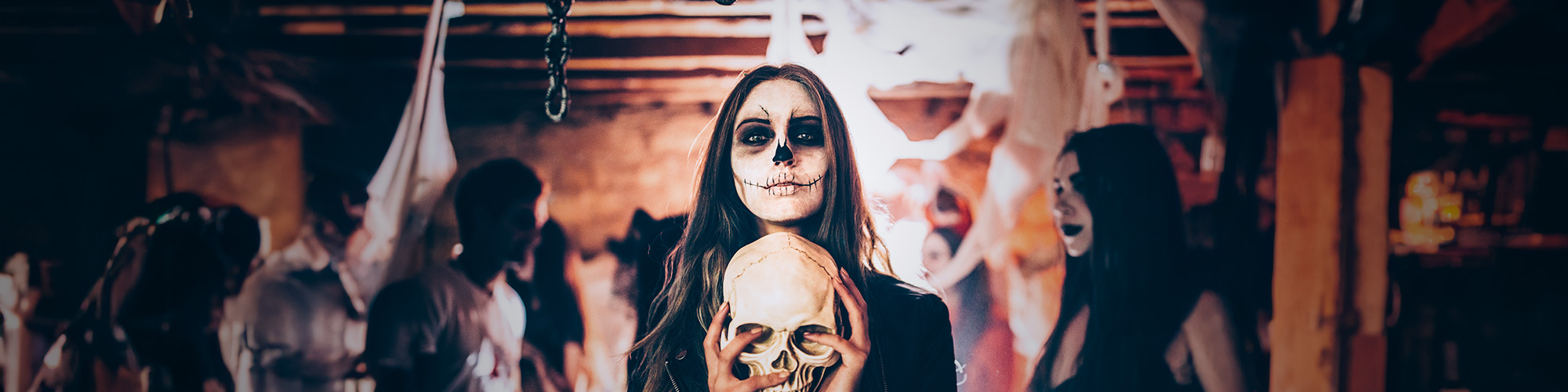 Woman painted for Halloween, while carrying a skull in her hands