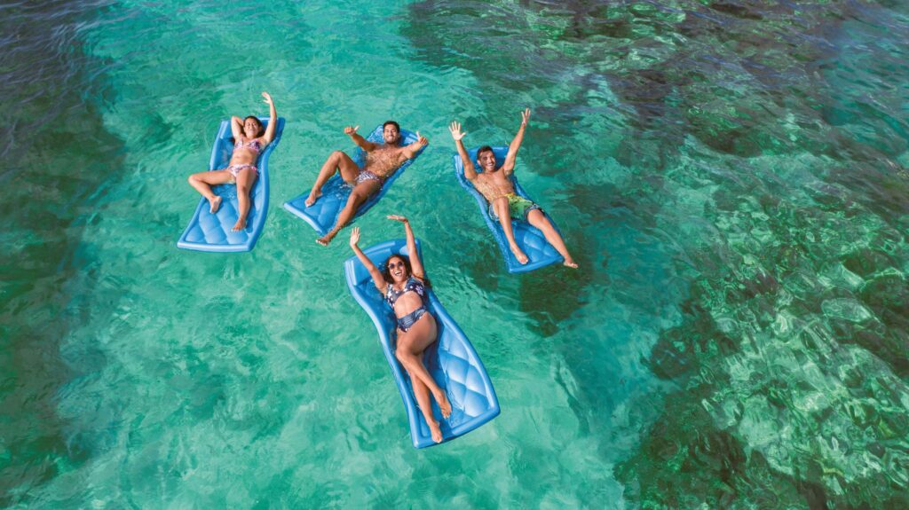 Group of friends floating in the sea in the Reef Explorer Excursion in Punta Cana