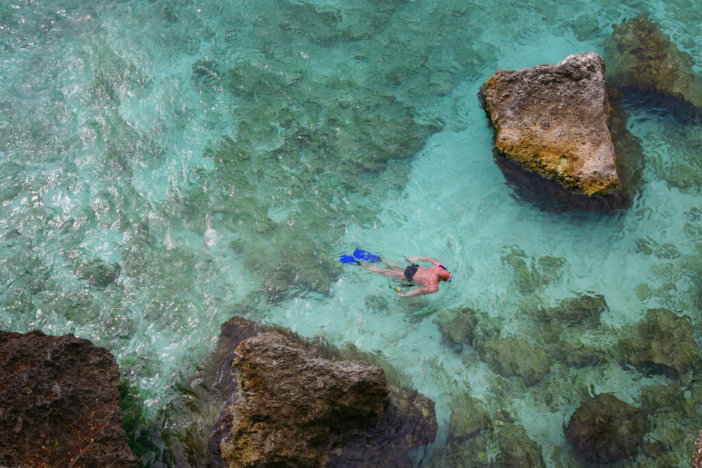 man snorkeling in tropical coral reef of Curacao