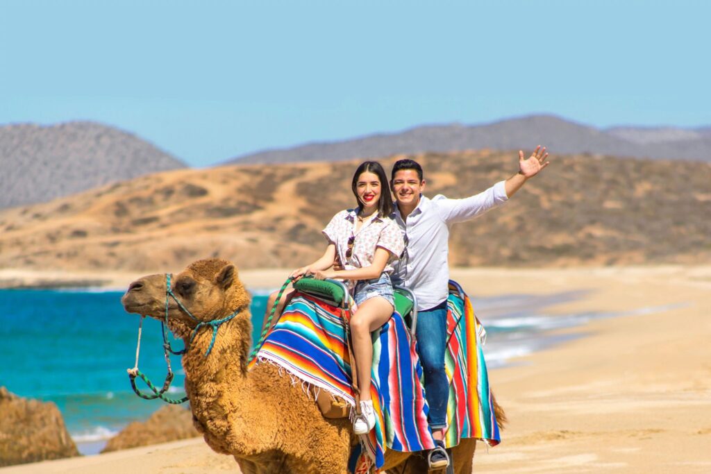 A couple enjoying a camel riding adventure in Los Cabos, Mexico.