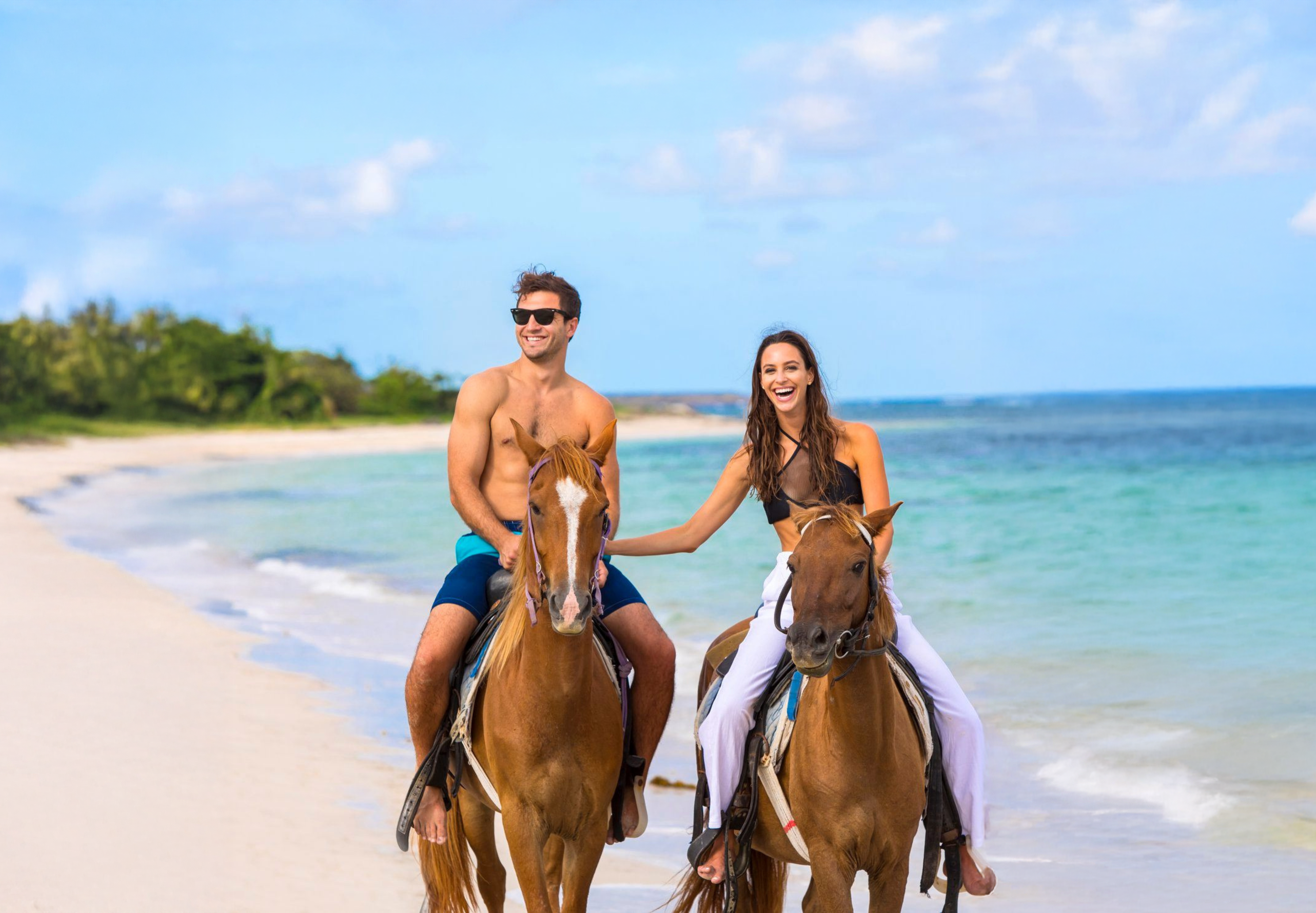 A couple riding horses on the island of Saint Lucia