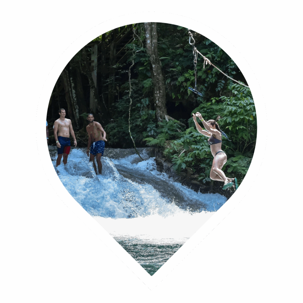 Woman jumping into the river on her private Blue Hole, Ocho Rios, Jamaica