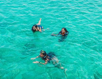 3 people swiming in the ocean near Aruba